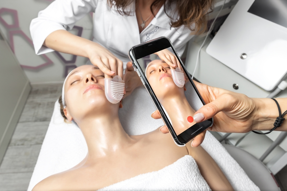 Mulher usando celular para gravar rosto de mulher sendo tratado
