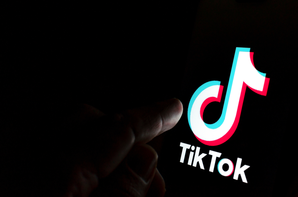 Logo do Tiktok sendo tocado por dedos