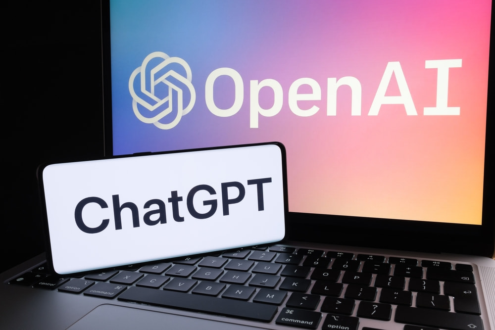 Celular com logo do ChatGPT e notebook com o logo da OpenAI, criadora do ChatGPT.